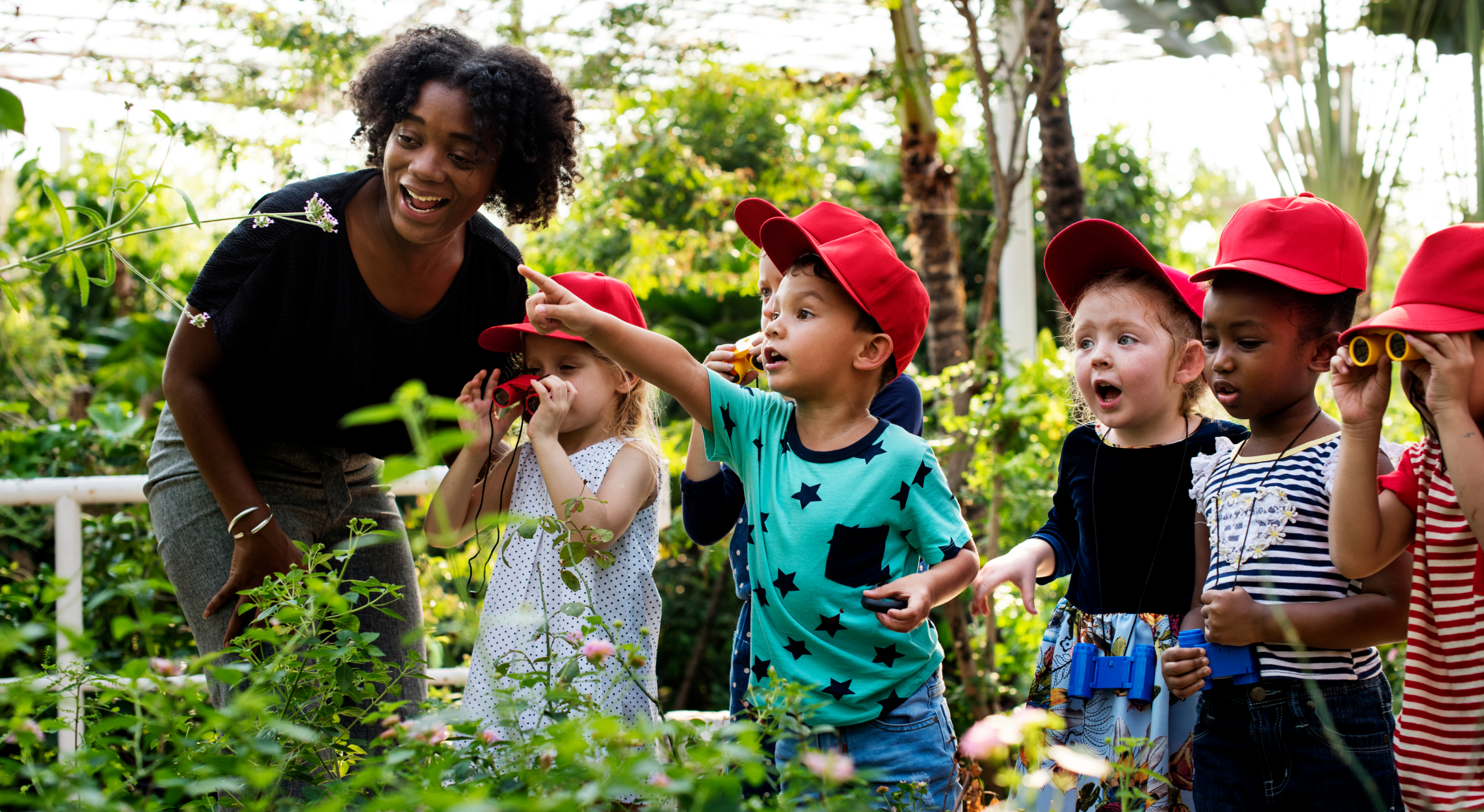 image showing teacher and children who are looking at plants with amazement